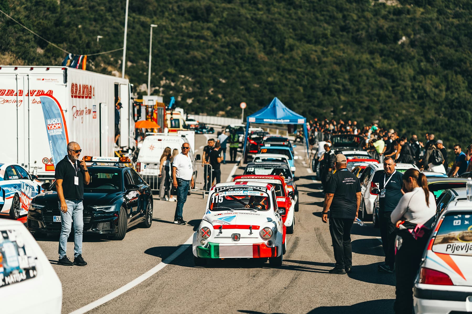 Cars lined up at an outdoor automotive event
